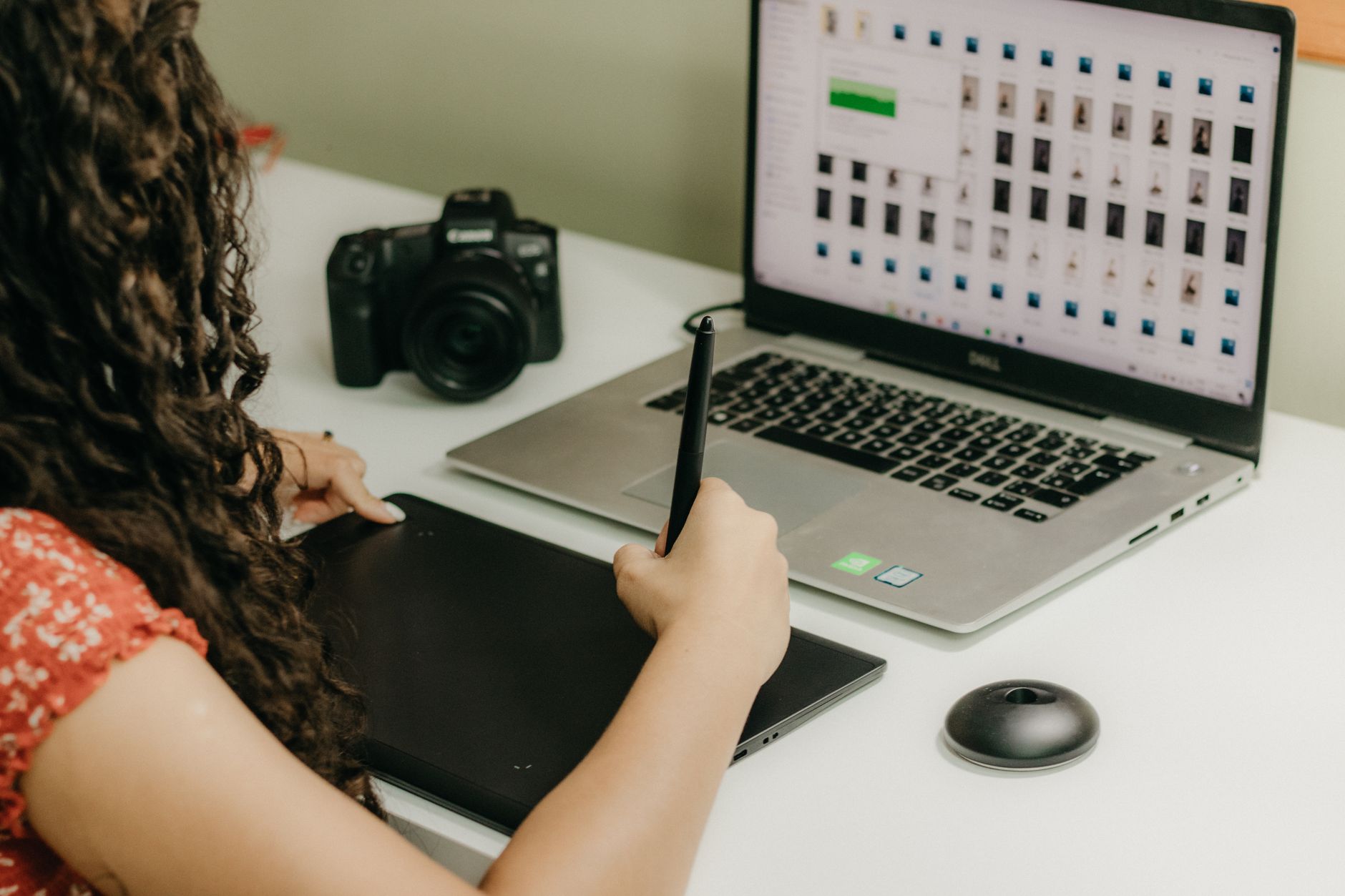 A woman comparing AI generated headshot portraits on a laptop screen