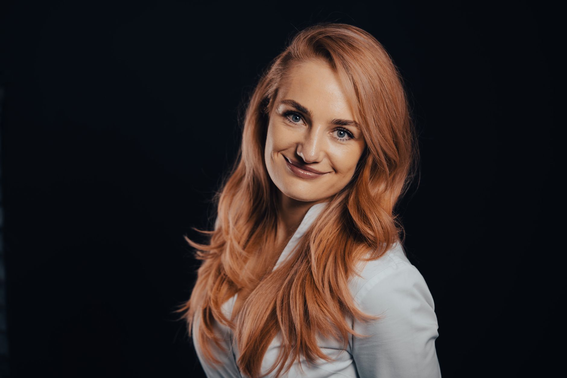 A photographer adjusting studio lights for a professional headshot session
