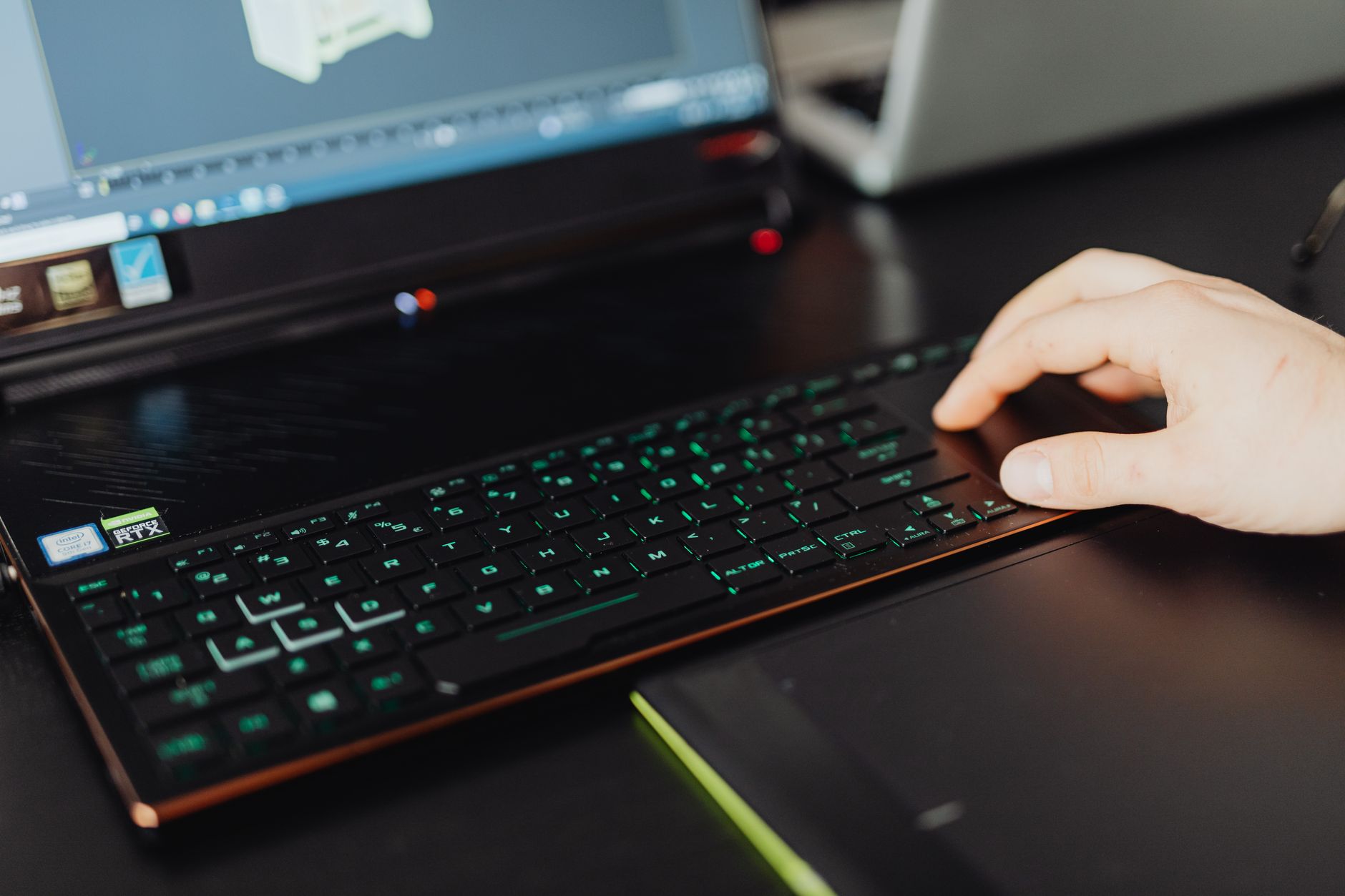 A designer generating a 3D model on a laptop in a creative studio.